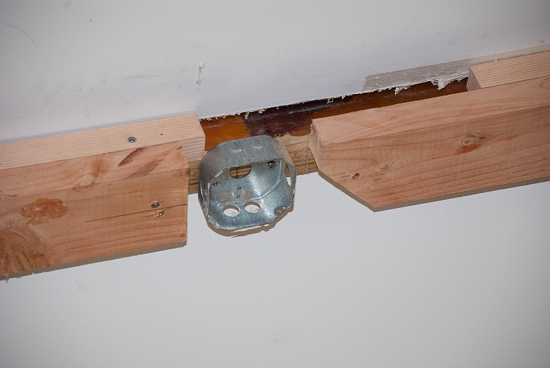 DSC_0963.jpg - Kris is continuing work on the family room ceiling beam.  First comes the rough inner structure.  Shown here is an electrical box for the ceiling fan.  (It's actually a stand-in for the real, heavier-duty box.)