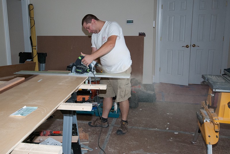 DSC_0249.jpg - This is "the other Chris,"  Krzystof Boruta, owner of Kris Construction, LLC.   Kris has been installing the closet cabinets, here working on the panels for the closet cabinets.  He has a great set of tools, like this Festool saw and guide rail.  The sawdust is really  flying.