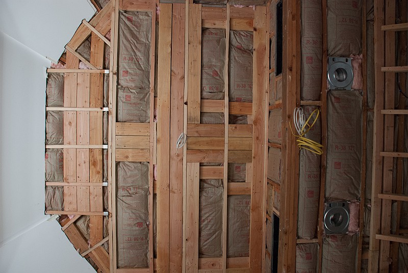 DSC_9758.jpg - That's a lot of framing and blocking in such a small part of the ceiling.  The fiberglass installers were working in 97 degree heat in the room.  It was easily 130 degrees in the attic space above the insulation, where they applied another layer.  I haven't installed a powered gable vent in this section yet, but I soon will.