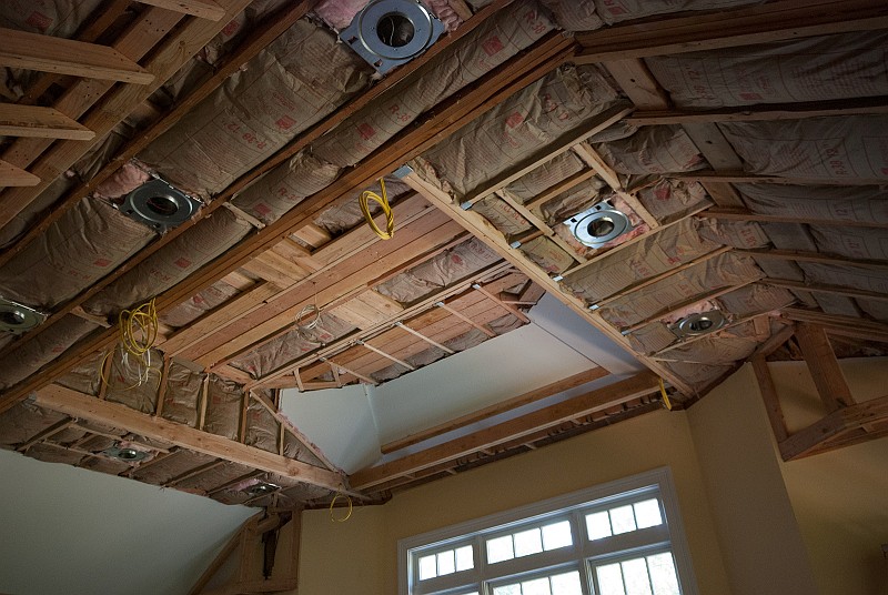 DSC_9767.jpg - The insulation crew arrived during our heat wave and applied the R-38 fiberglass to the ceilings.  The hanging yellow Romex is for cove lighting that will be added later.  The white Romex in the center is for the ceiling fan.