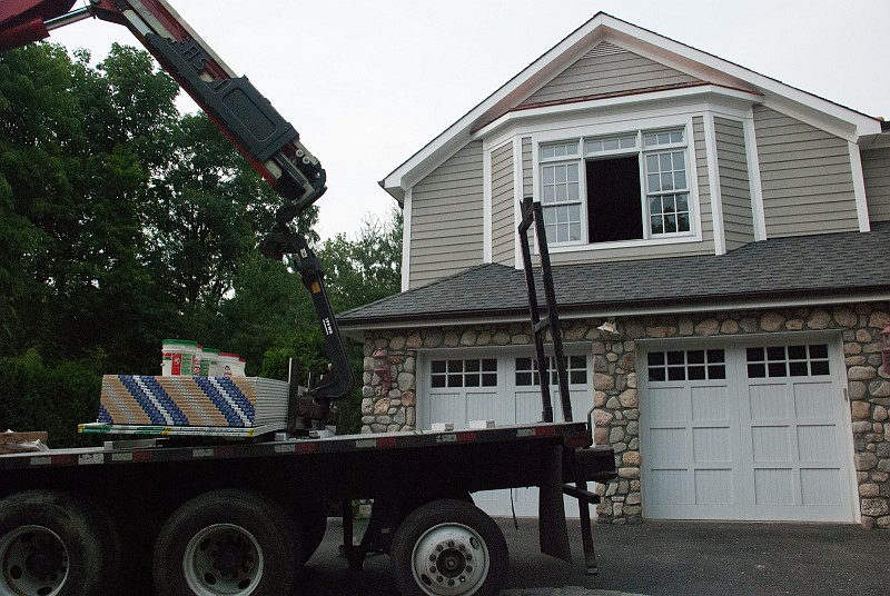DSC_9774.jpg - The truck with our sheetrock arrives, but rain is on the way.  It has already taken 20 minutes to back the truck around the bend in the driveway.  If the truck was 6 inches longer I don't think it would have made it.   Now it is a race against the weather.  
