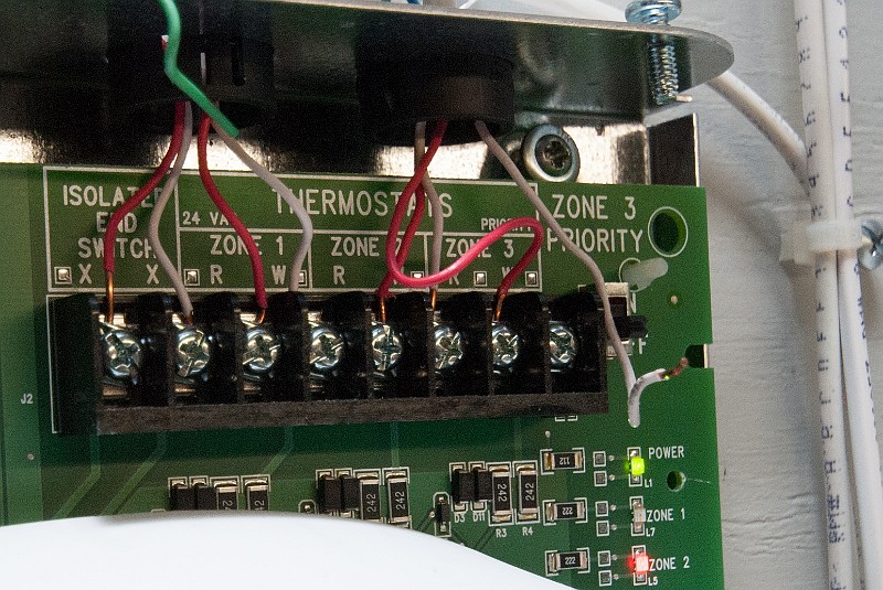 DSC_2806.jpg -  ... Yes, why isn't that white 24VAC wire connected to the last terminal?  That stupid wire is just hanging out all by itself.  Logically, it should be providing power to the power relay for hot water circulator pump #9.  So I connected it and waited. (Note: Zones 1 to 6 are in the first panel, so these three shown here are actually Zones 7, 8 and 9.)  Was that wire intentionally, or accidentally, disconnected ?  We may never know.
